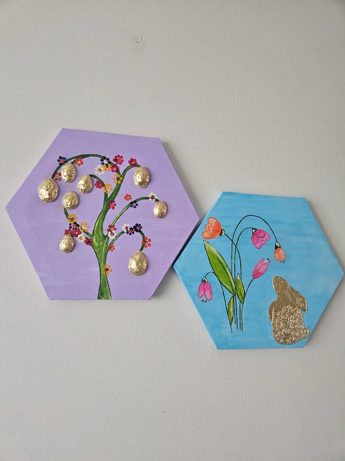 Two hexagonal art pieces with a tree and bunny on a plain background