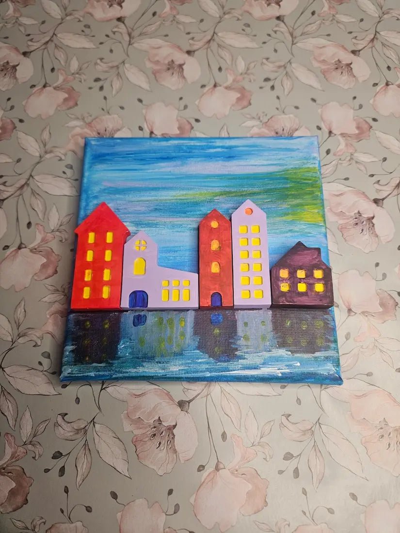 Children's painting of colorful houses on a floral-patterned background